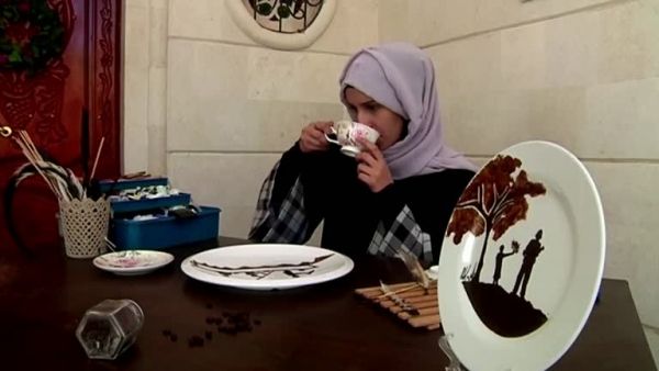 يمنية ترسم بالبُن المطحون للتعبير عن هوية بلدها